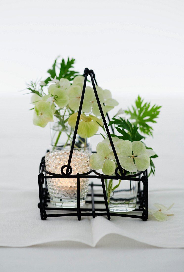 Tischdekoration mit Windlicht und Vasen mit Hortensienblüten