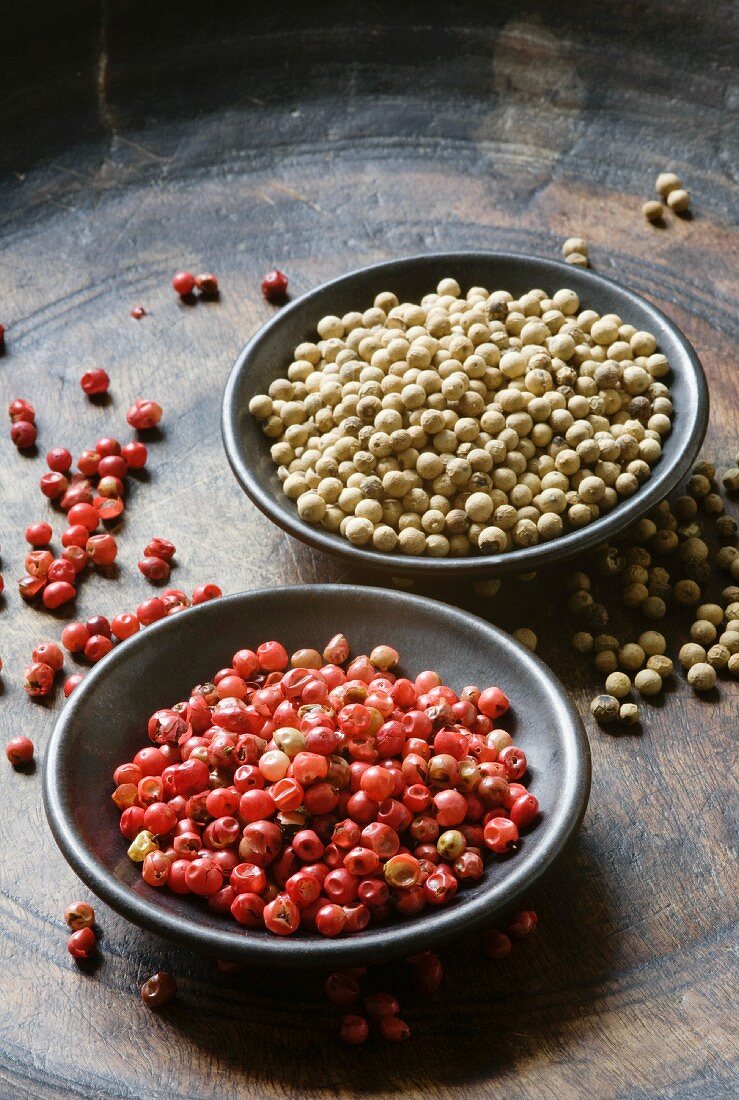 Red and white peppercorns in bowls