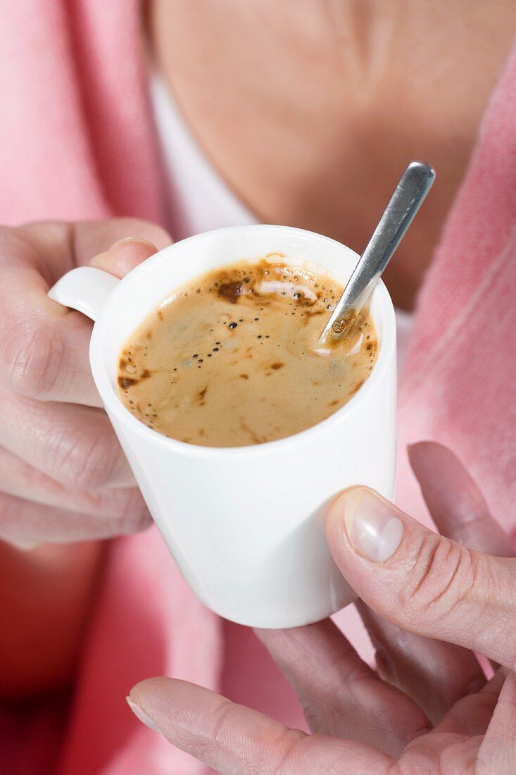 A woman holding a cup of coffee