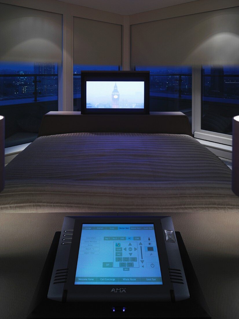 Flat-screen TV at foot of double bed in front of panoramic window with half-closed blinds