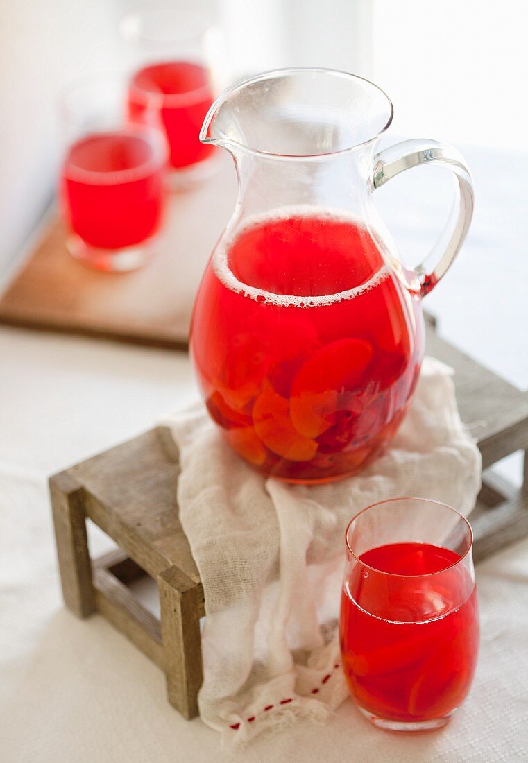 Punch with summer fruits in a pitcher and glasses