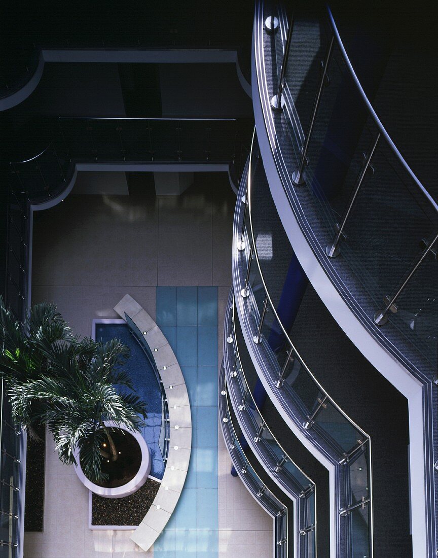 Top view of palm and pool in open central lobby of apartment block