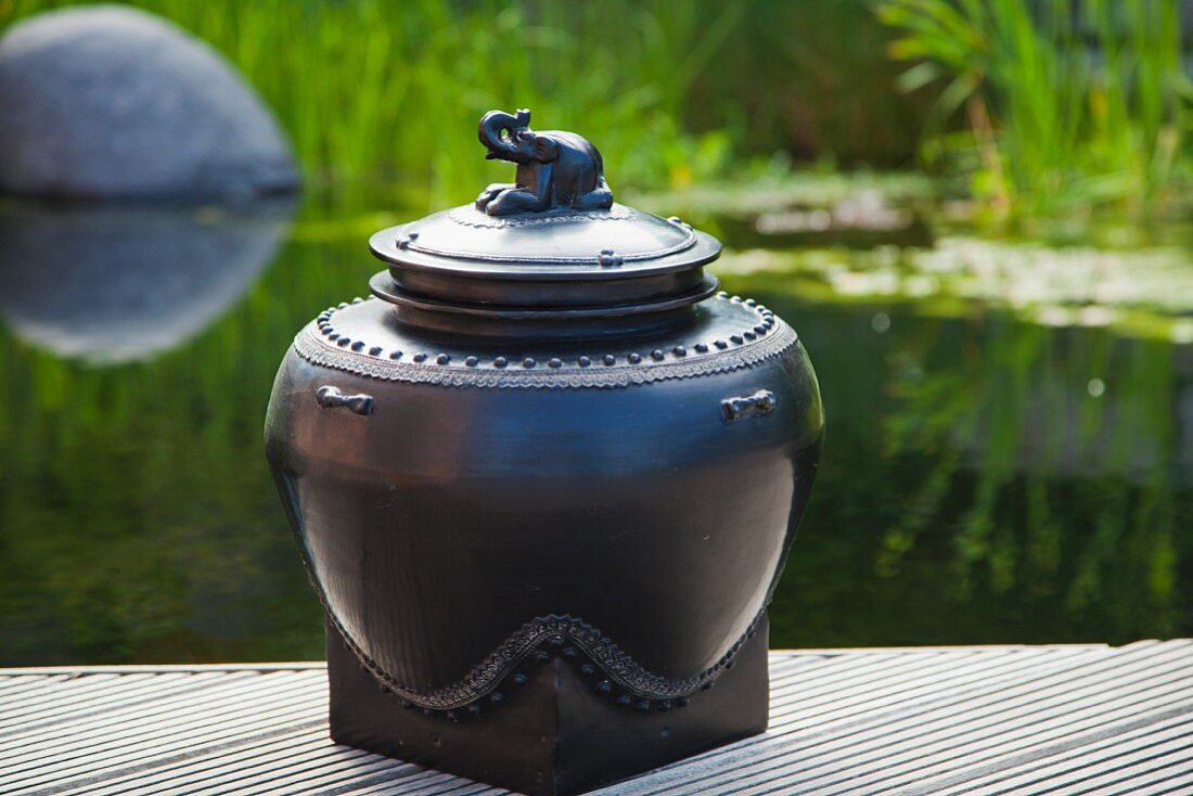 Lacquerware pot with elephant next to pond