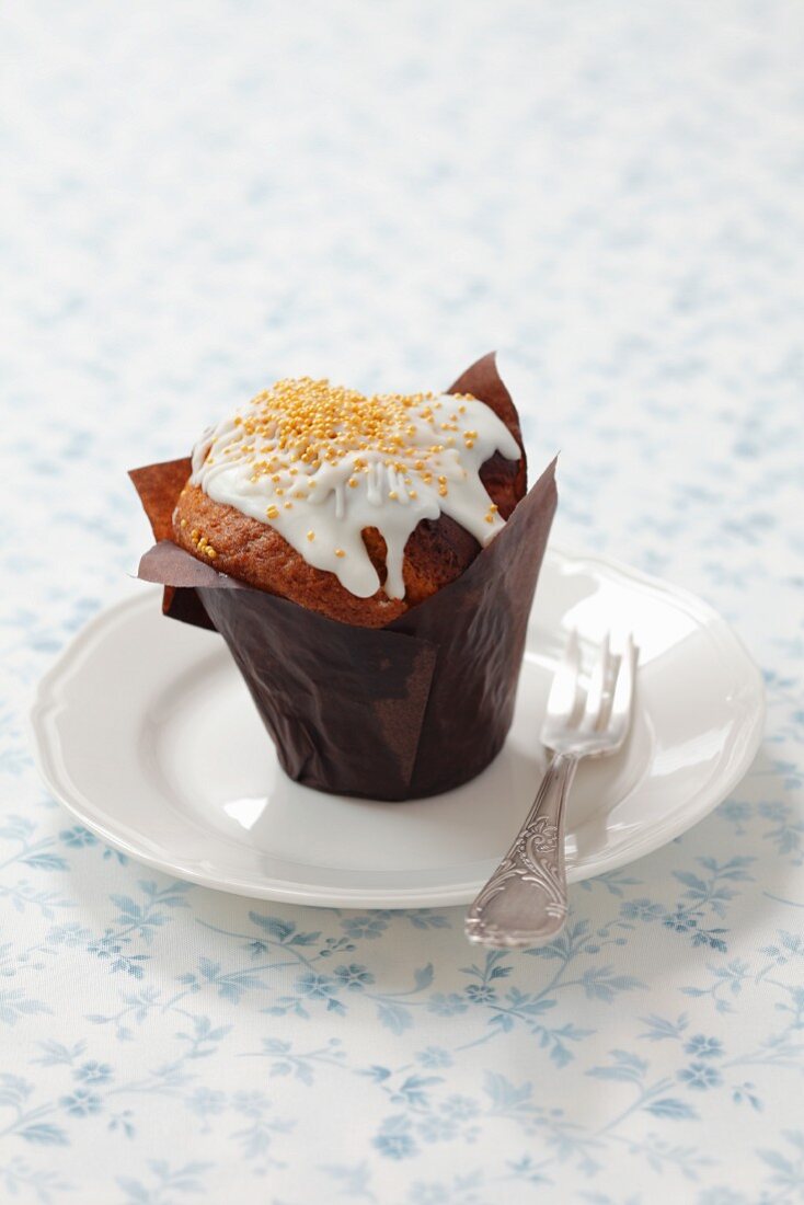 Muffin with icing and gold sprinkles