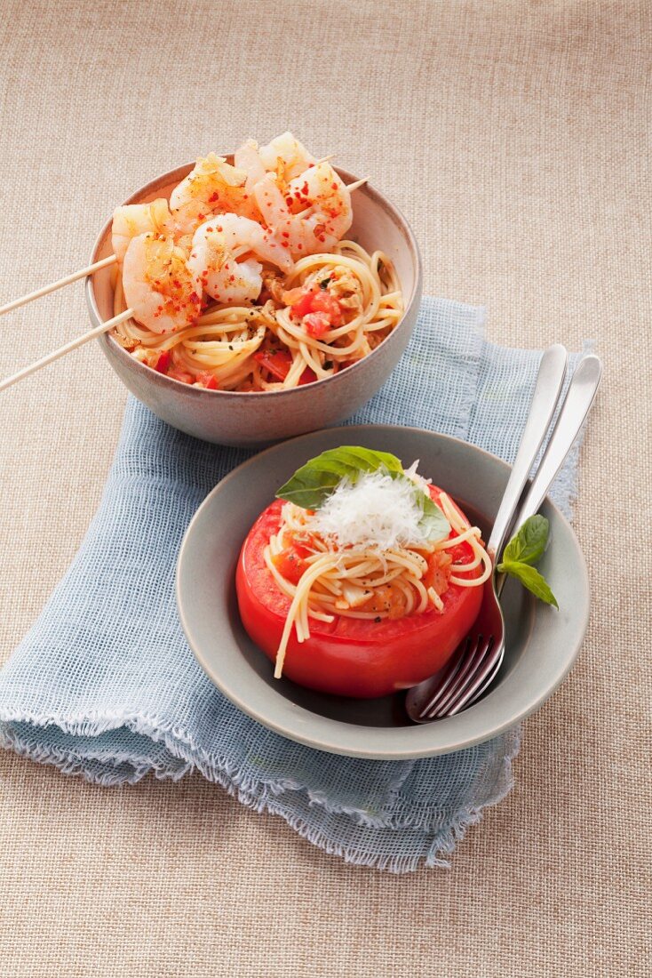 Shrimp kebabs on spaghetti and stuffed tomatoes with spaghetti