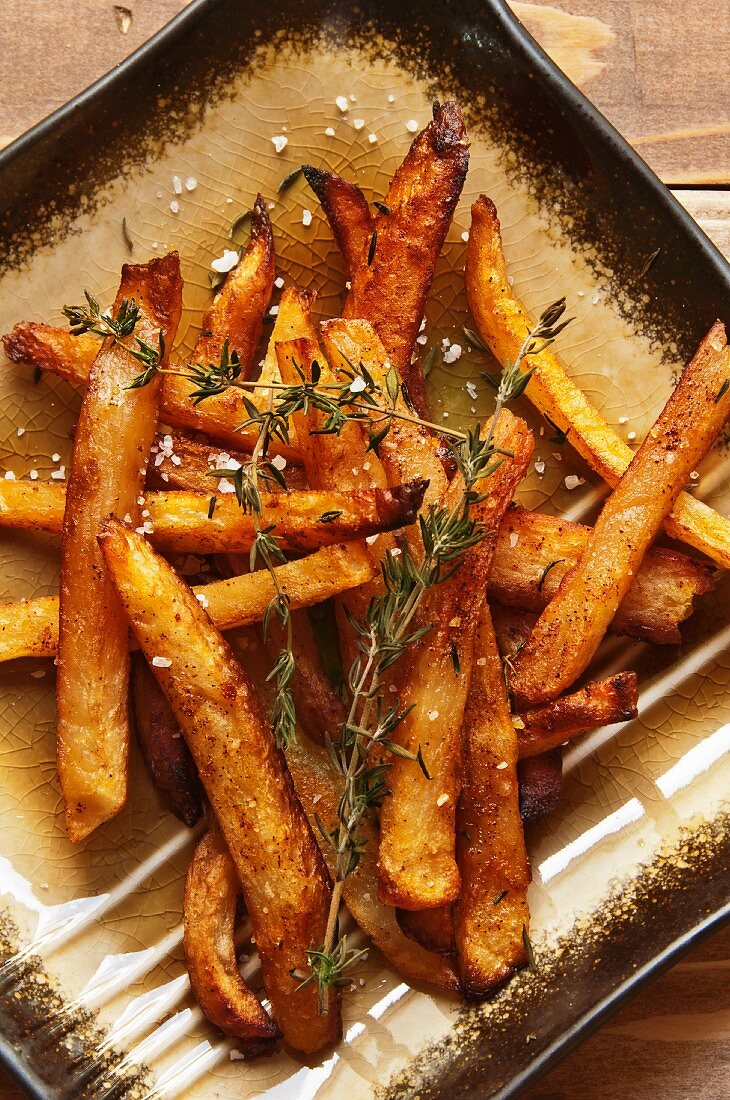 Homemade Fries with Thyme Sprigs on a Plate