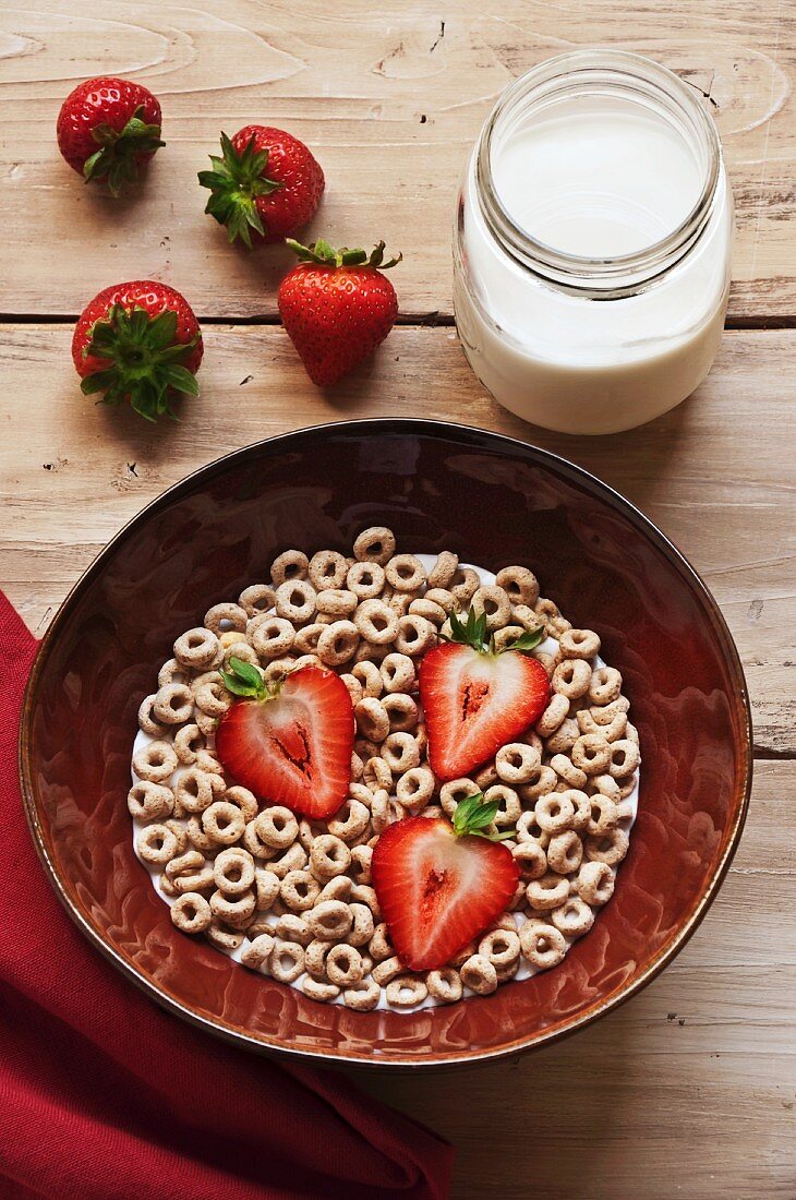 Bowl of Rolled Oat Cereal with Strawberries; Jar of Milk