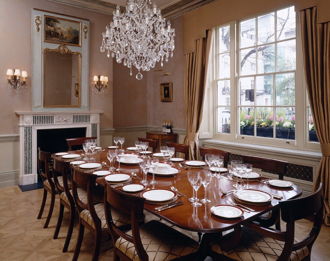 Crystal chandelier above set table in luxurious dining room