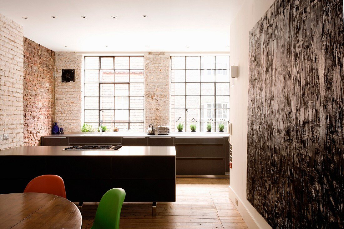 Open-plan kitchen in former factory premises with brick wall