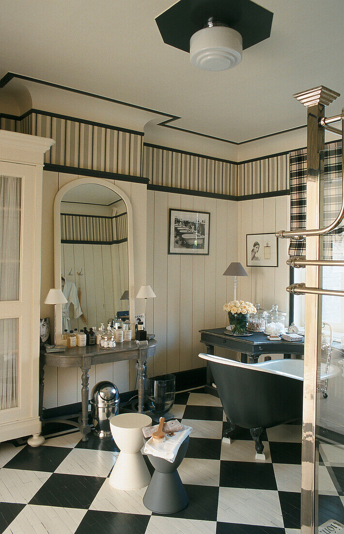 Bathroom with black and white checkered floor and free-standing bathtub