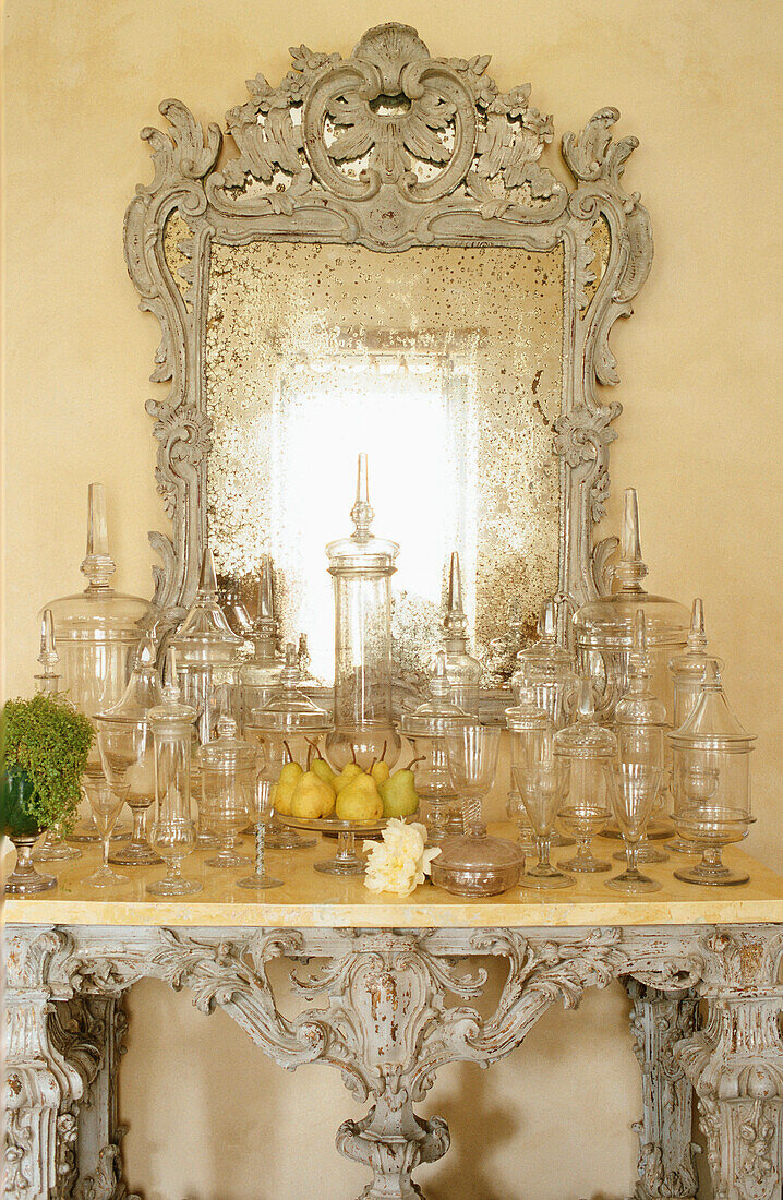 Antiker Spiegel über Konsole mit Glasgefäßen im barocken Stil