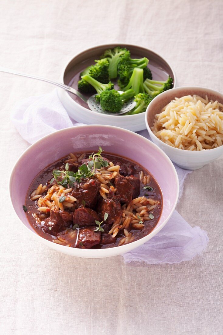 Lamb goulash with rice-shaped pasta and broccoli