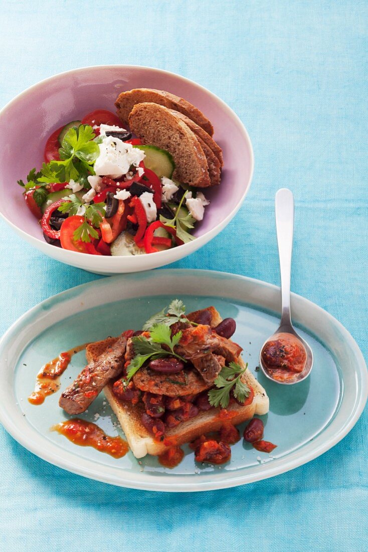 Beef with kidney beans on toast and fresh vegetables with feta