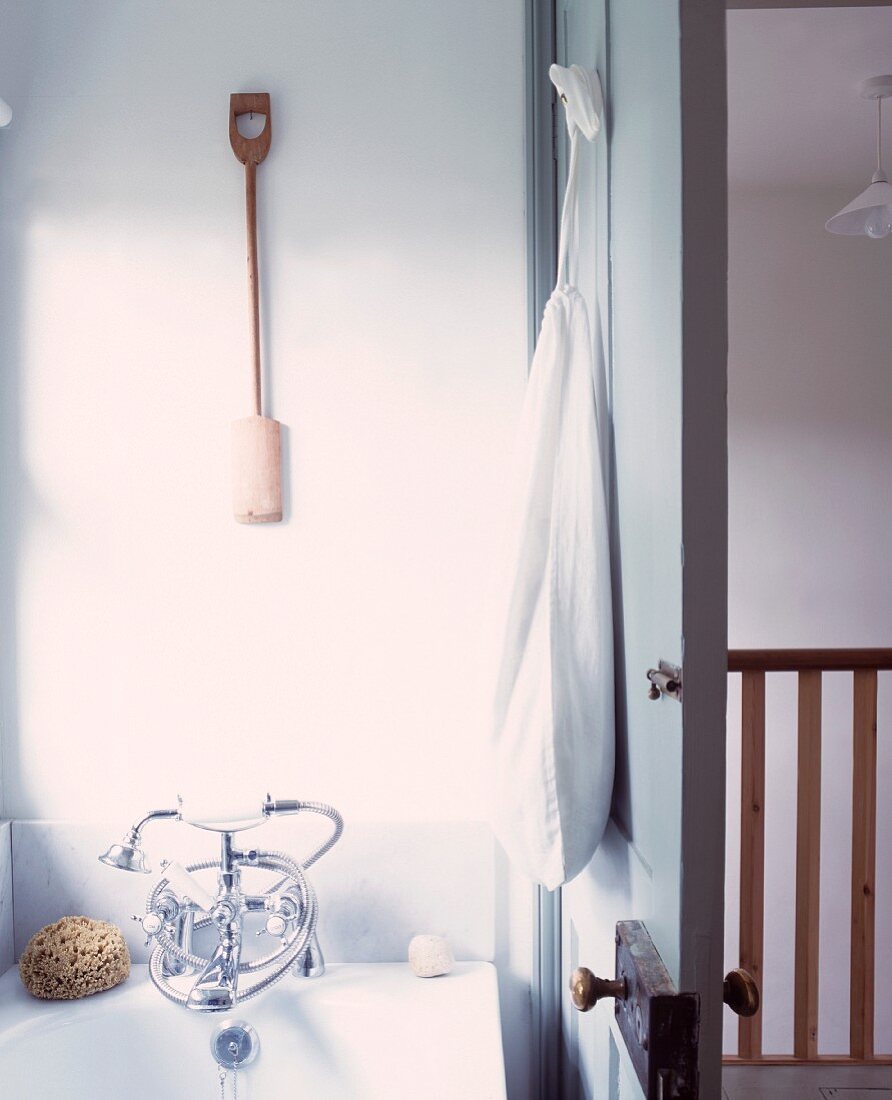 Bathtub with vintage tap fittings and open door with view of landing