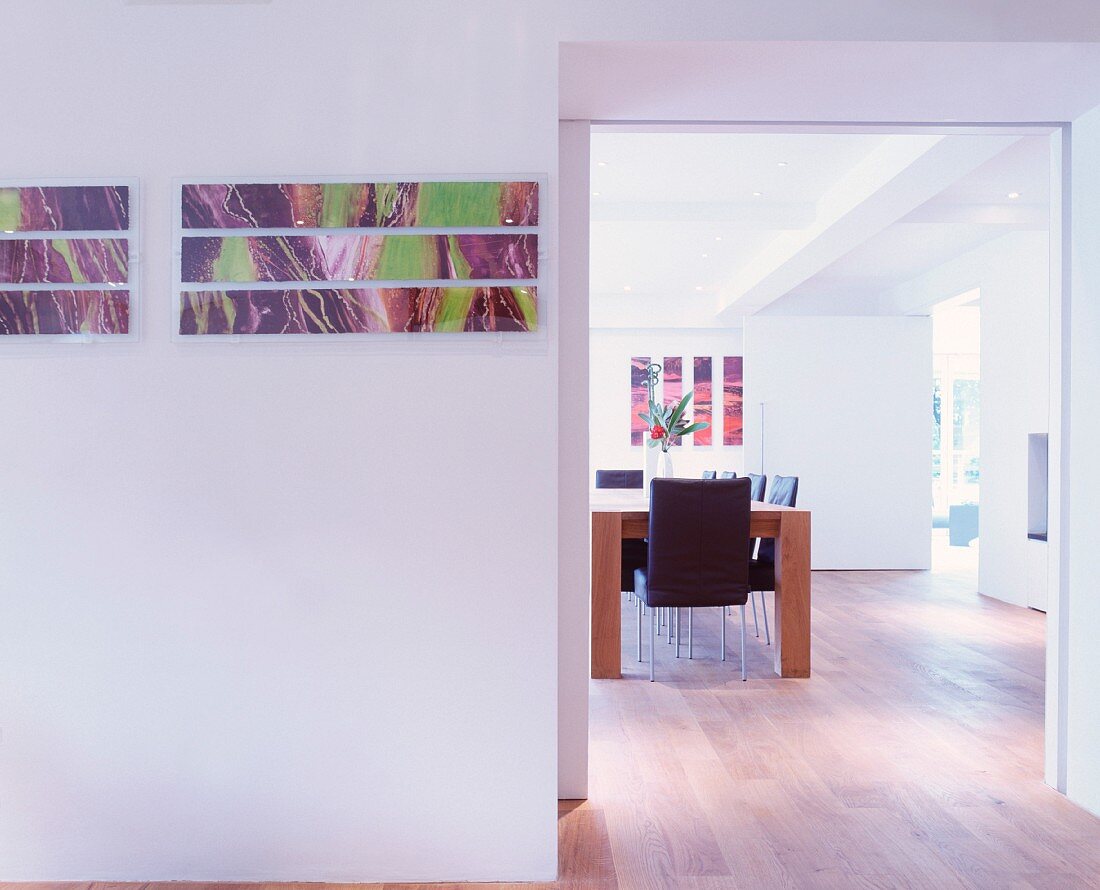 Moderne Bilder an Wand neben breitem Durchgang und Blick auf Esstisch