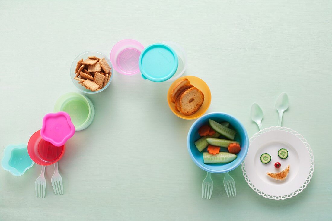 A caterpillar of colourful crockery with snacks
