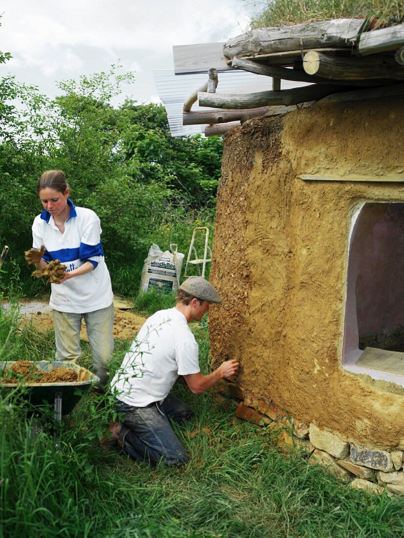 Working on facade surface of organic clay house