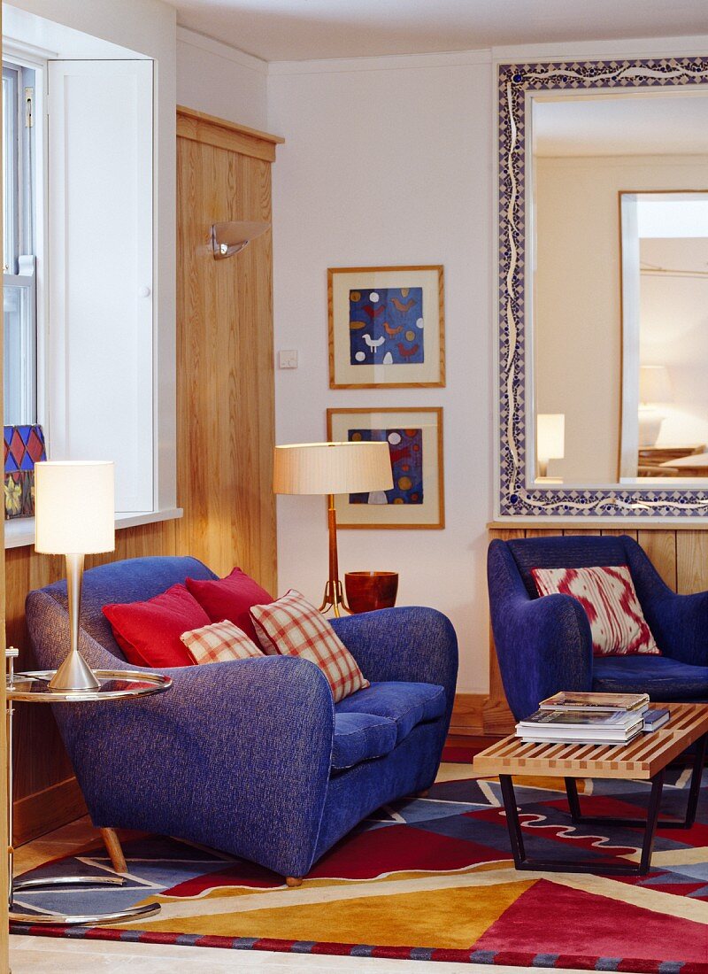 Living room with armchair, sofa, side table & large mirror