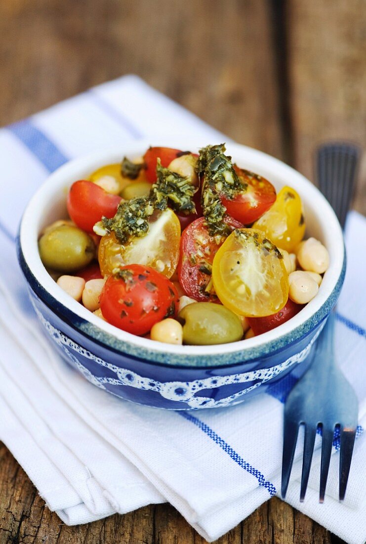 Tomato salad with yellow and red tomatoes, chickpeas and pesto dressing