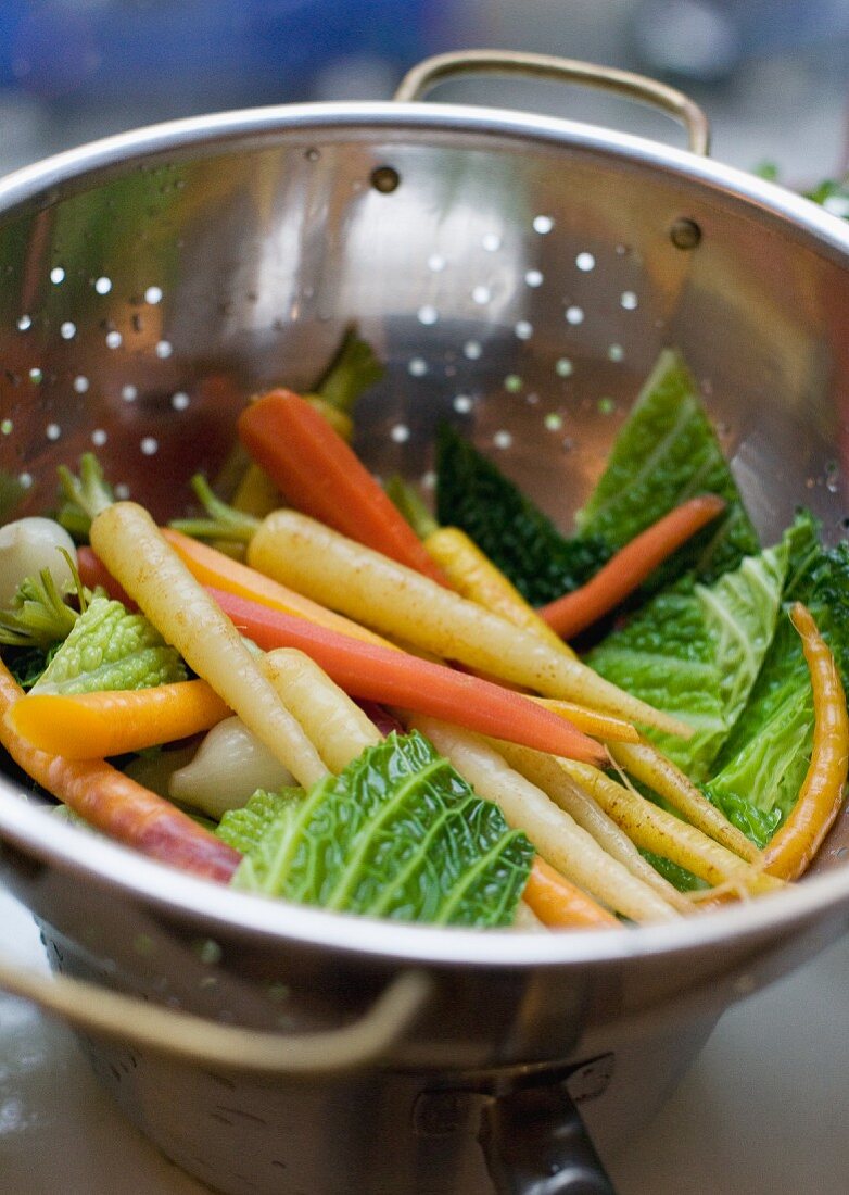 Gewaschenes Gemüse im Küchensieb (Möhren, Zwiebeln, Wirsing)