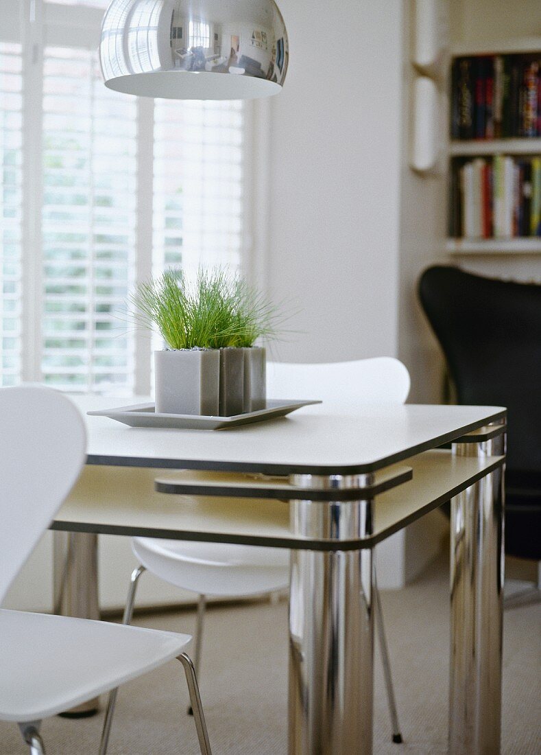 Small dining area in cool black and white with designer furniture and retro lamp