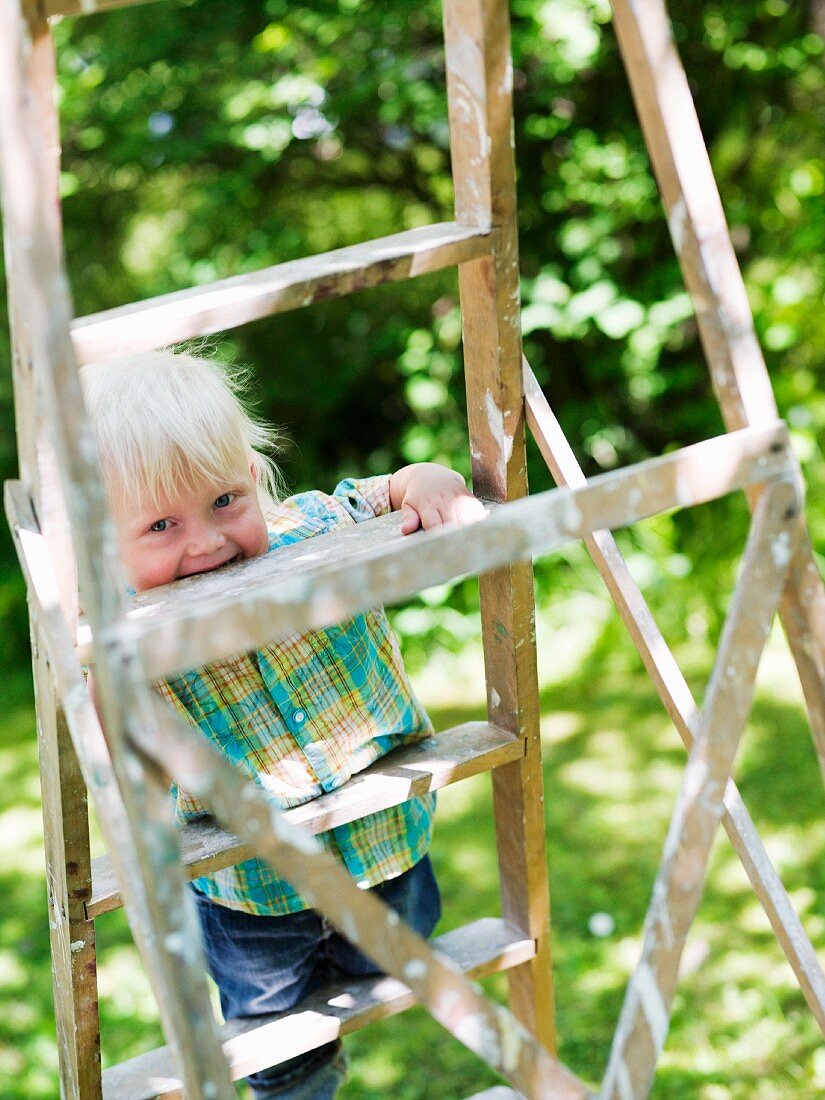 Laughing child on a wooden ladder