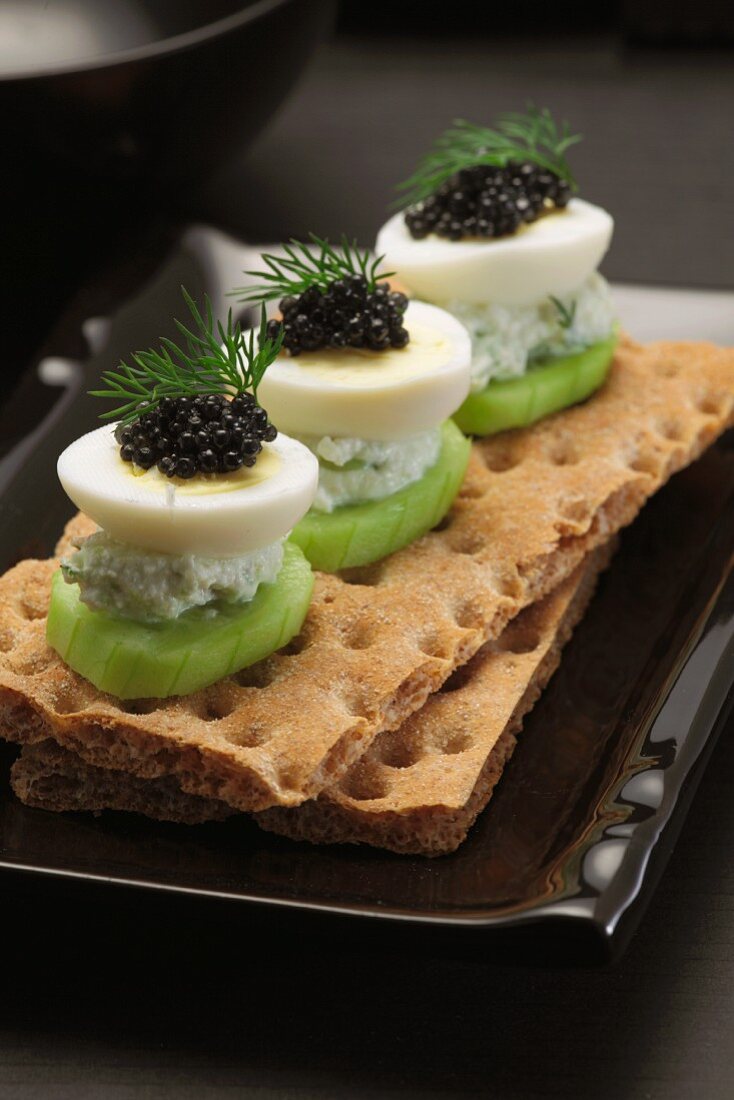 Crispbread with cucumber, boiled egg and black caviar