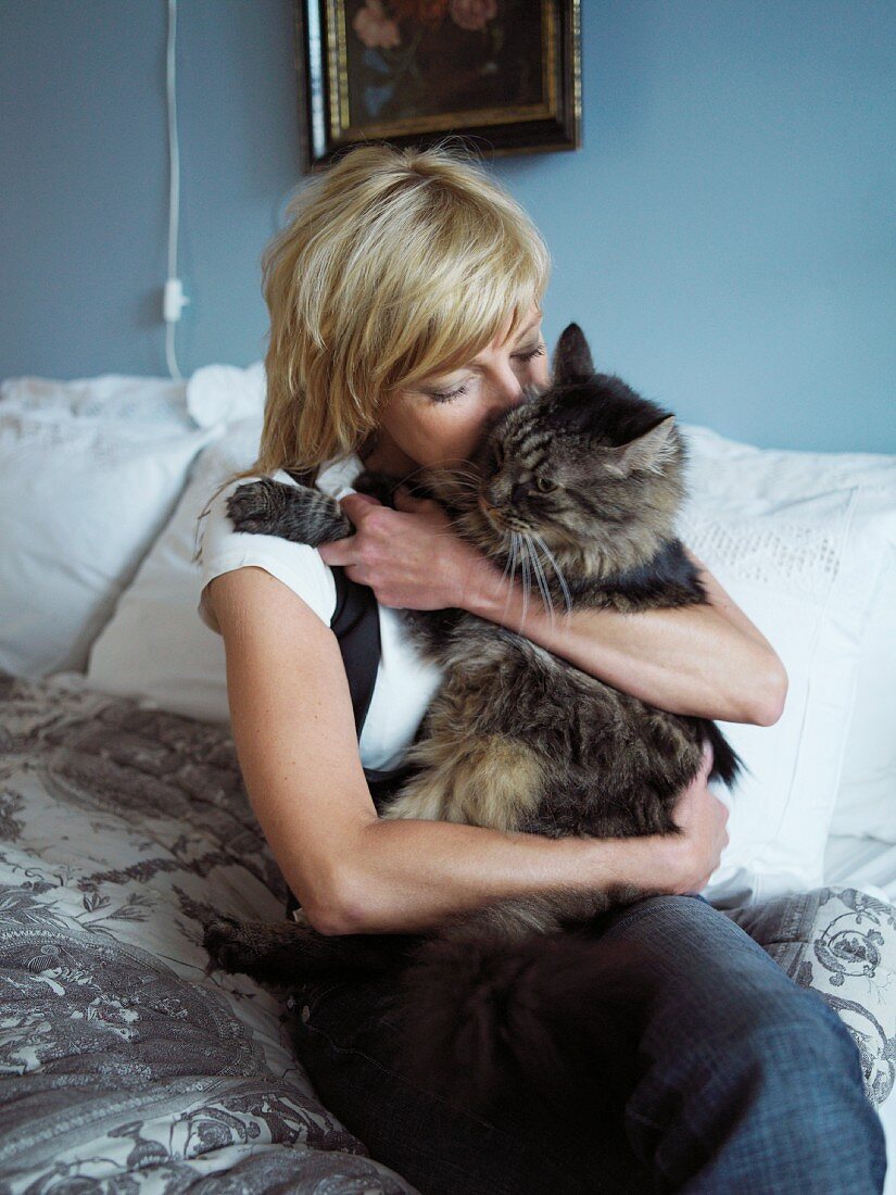 Frau mit Katze auf dem Bett