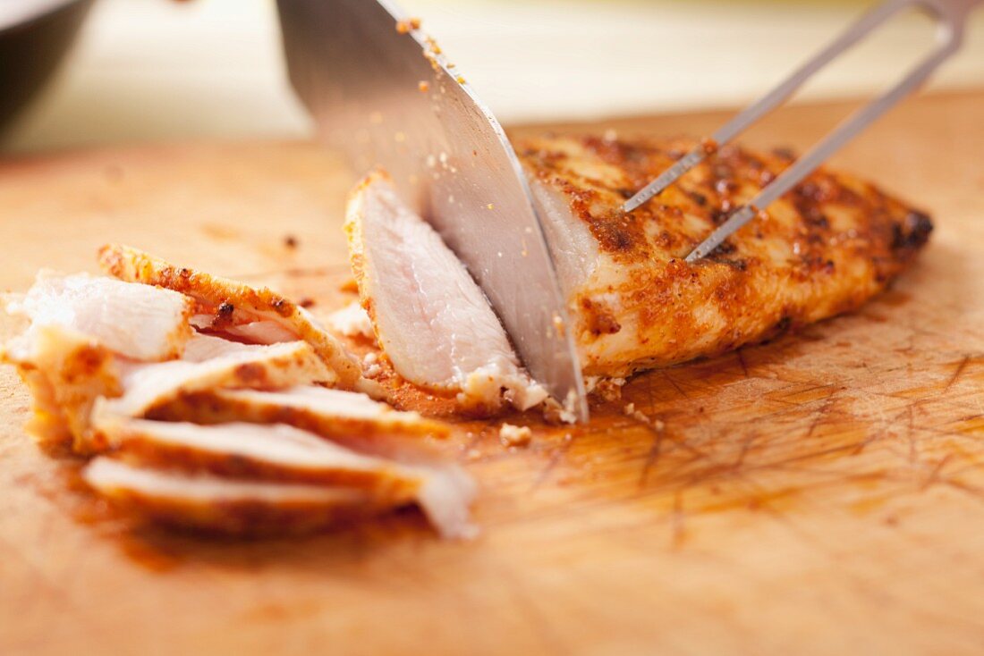 Cutting grilled chicken breast into thin strips