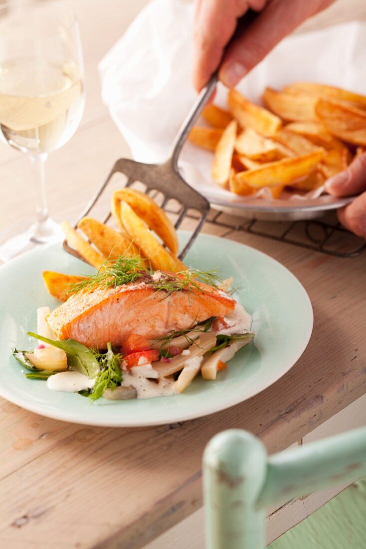 Salmon fillet on vegetables with chips