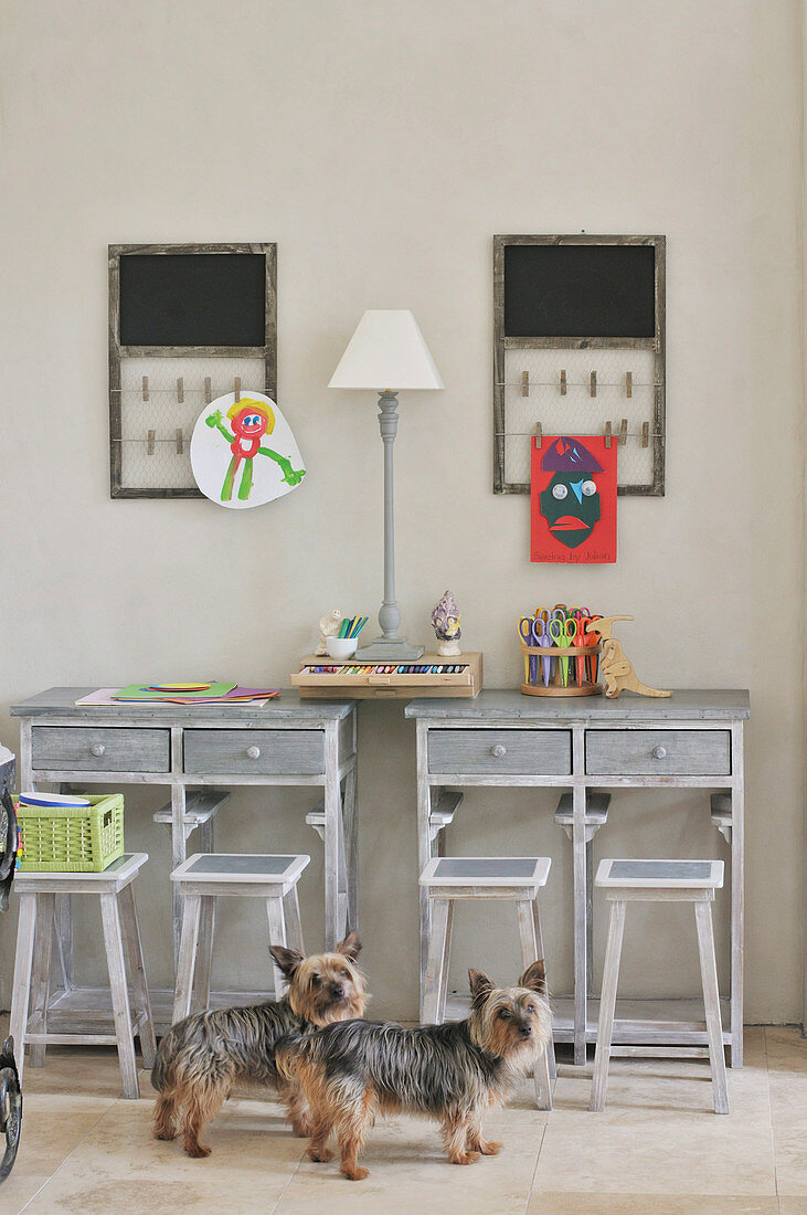 Small dogs in child's bedroom with rustic desks and stools