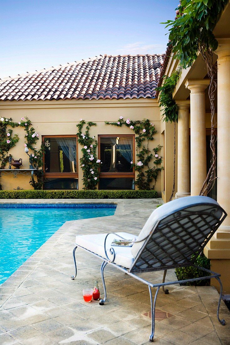 Elegant garden lounger on side of pool in grand villa complex