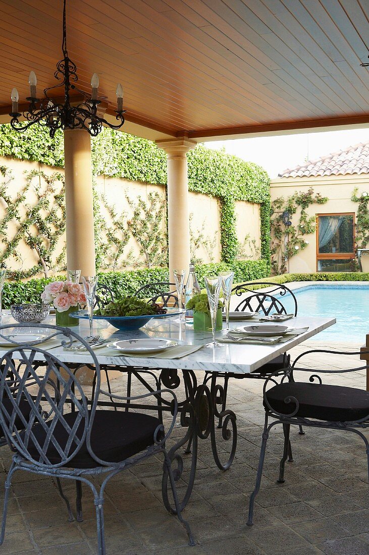 Gedeckter Tisch auf überdachter Terrasse und Pool im herrschaftlichen Anwesen