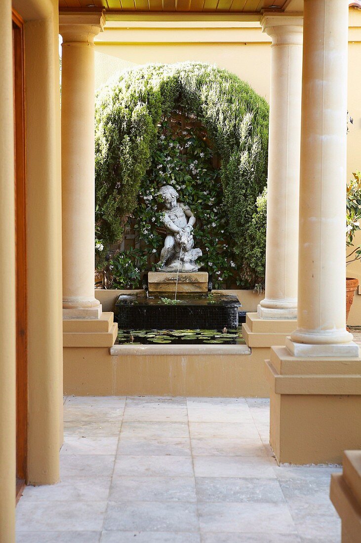 View along colonnade to ornamental fountain with stone figure