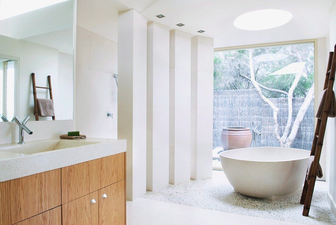 Bathtub with free-standing bathtub and glass wall leading to terrace