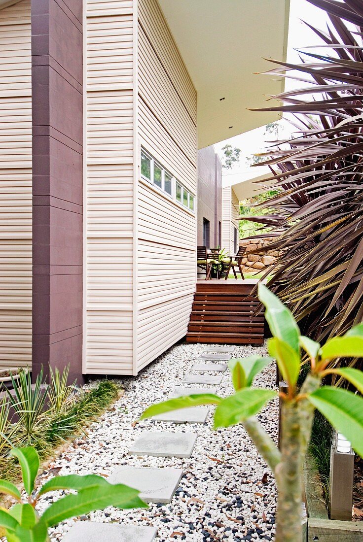 Residential house with slatted cladding and wooden steps leading to terrace