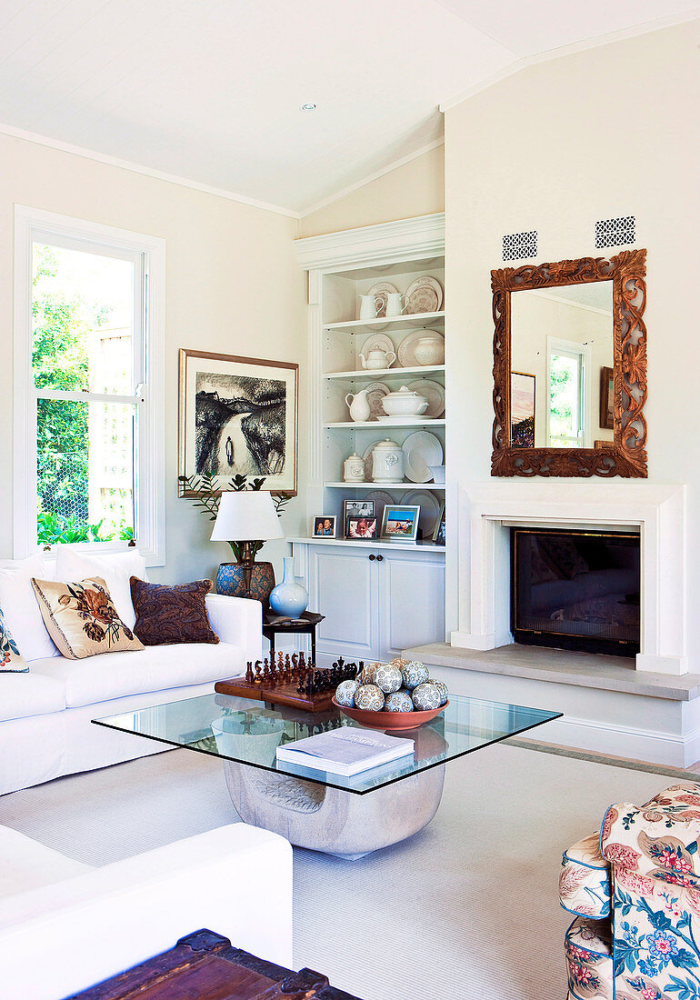 Living room with glass-topped coffee table in front of open fireplace