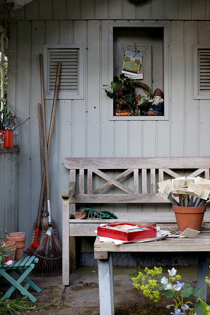 Wooden bench in seating area outside garden shed