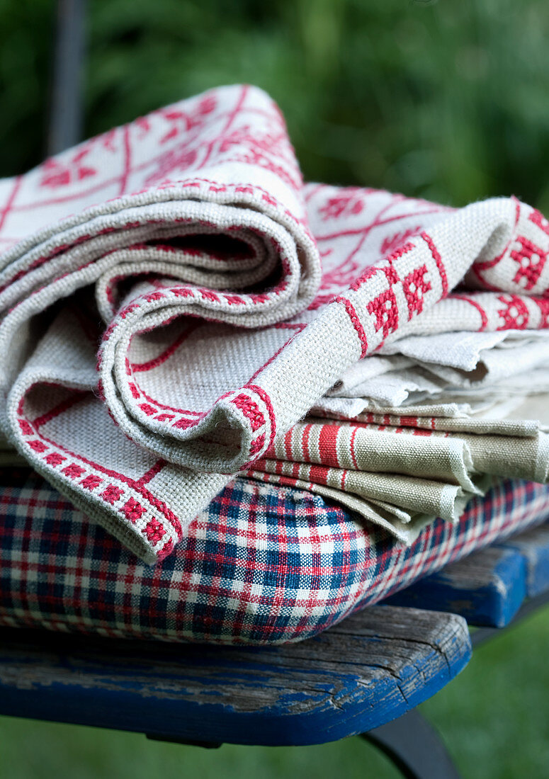 Cushion and folded table linen on garden chair