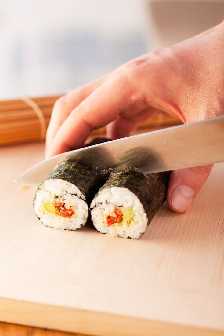 Maki-Sushi in Stücke schneiden