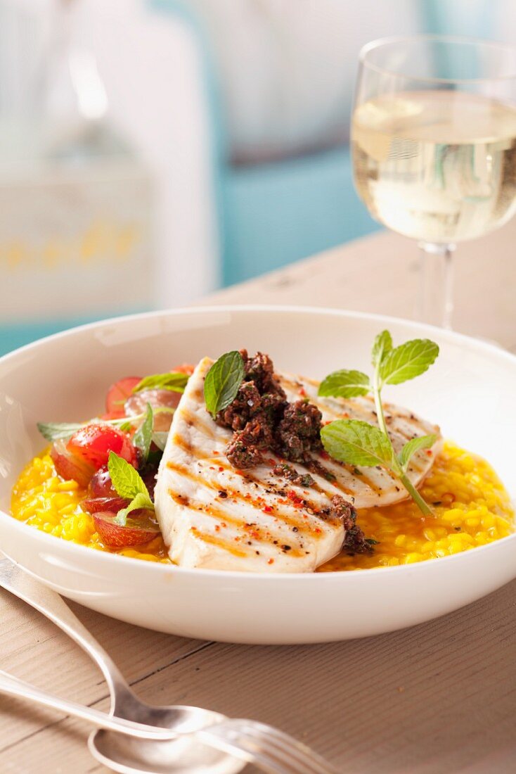 Grilled sword fish with tapenade on saffron risotto