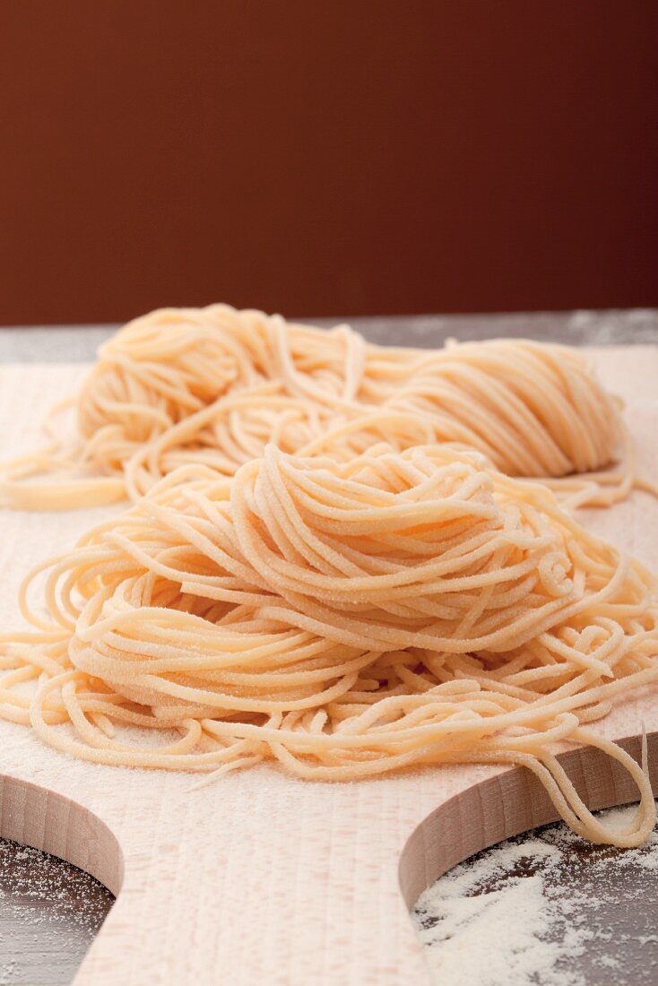 Selbstgemachte Spaghetti auf einem Holzbrett