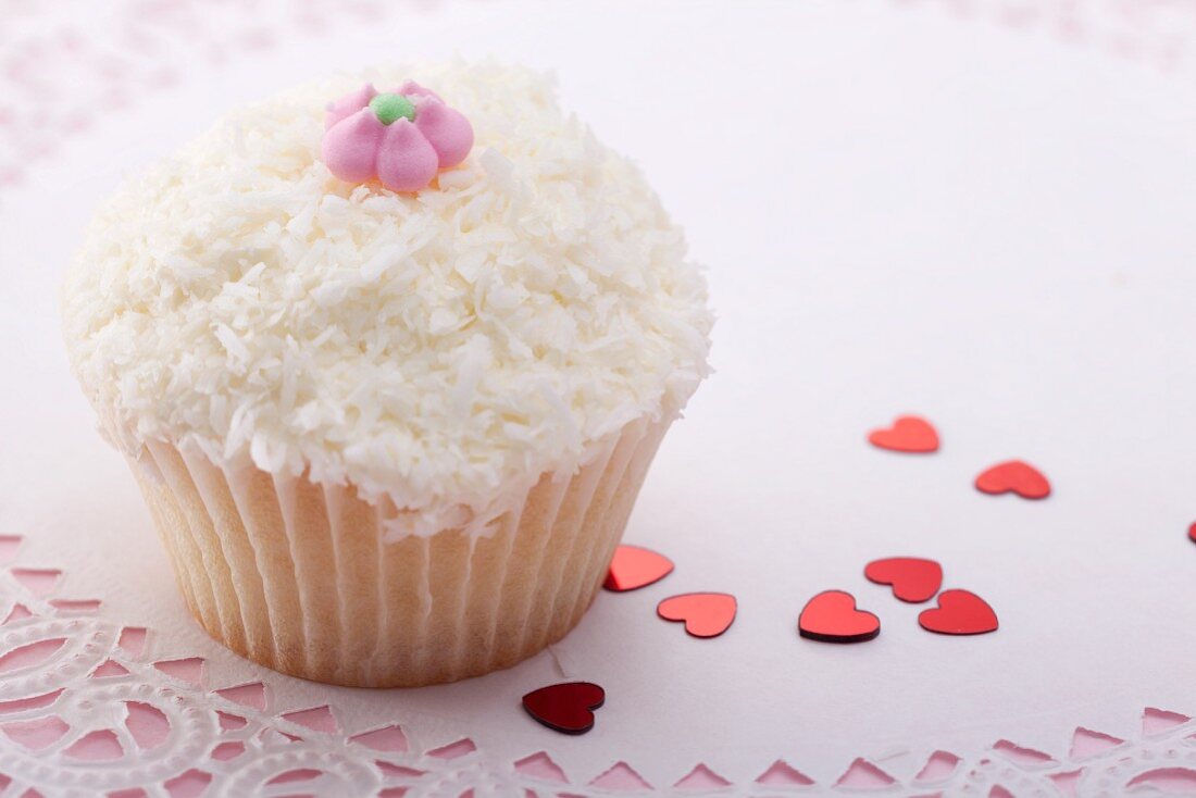 Cupcake with grated coconut and sugar flower