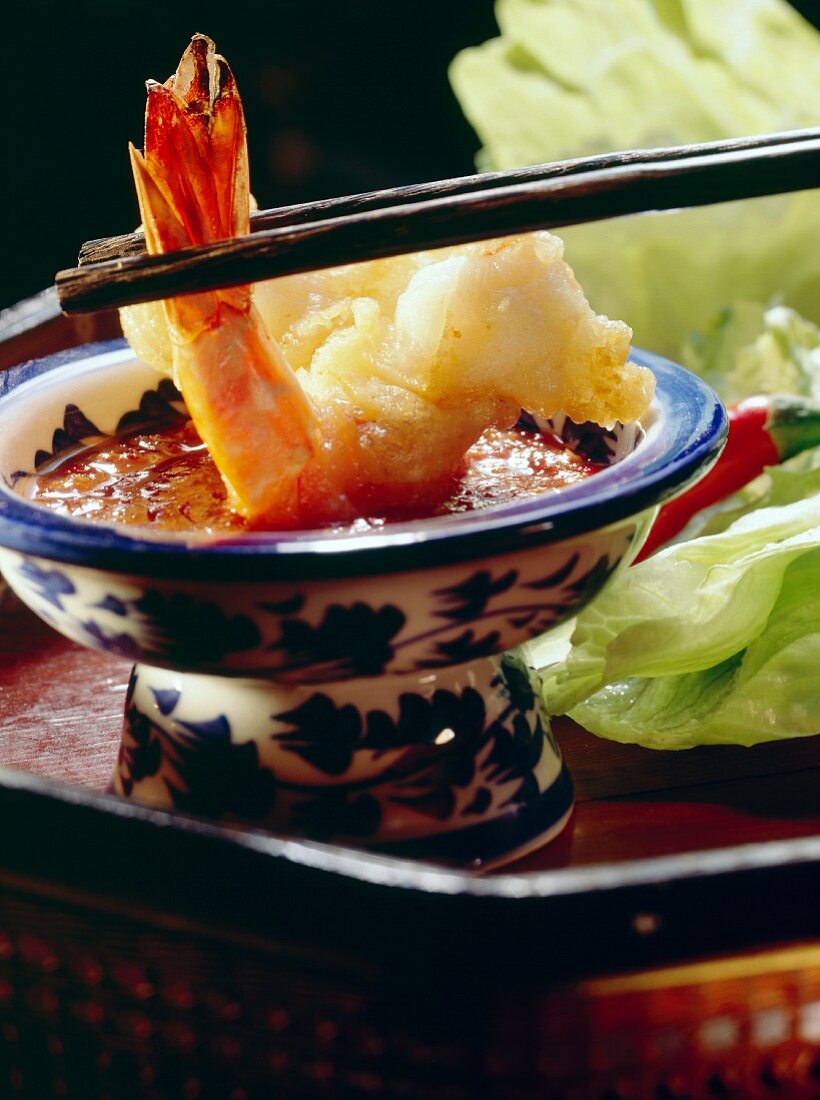 Fried scampi and chili dip in bowl with chop sticks