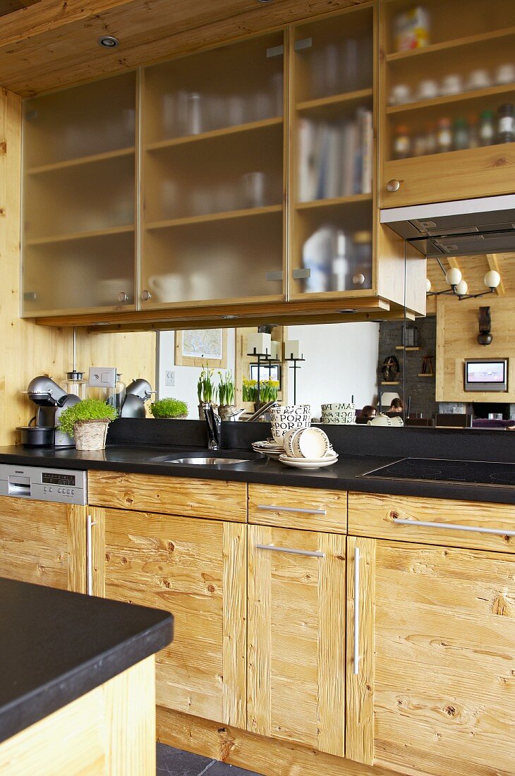 Detail of rustic kitchen units with mirrored splashback