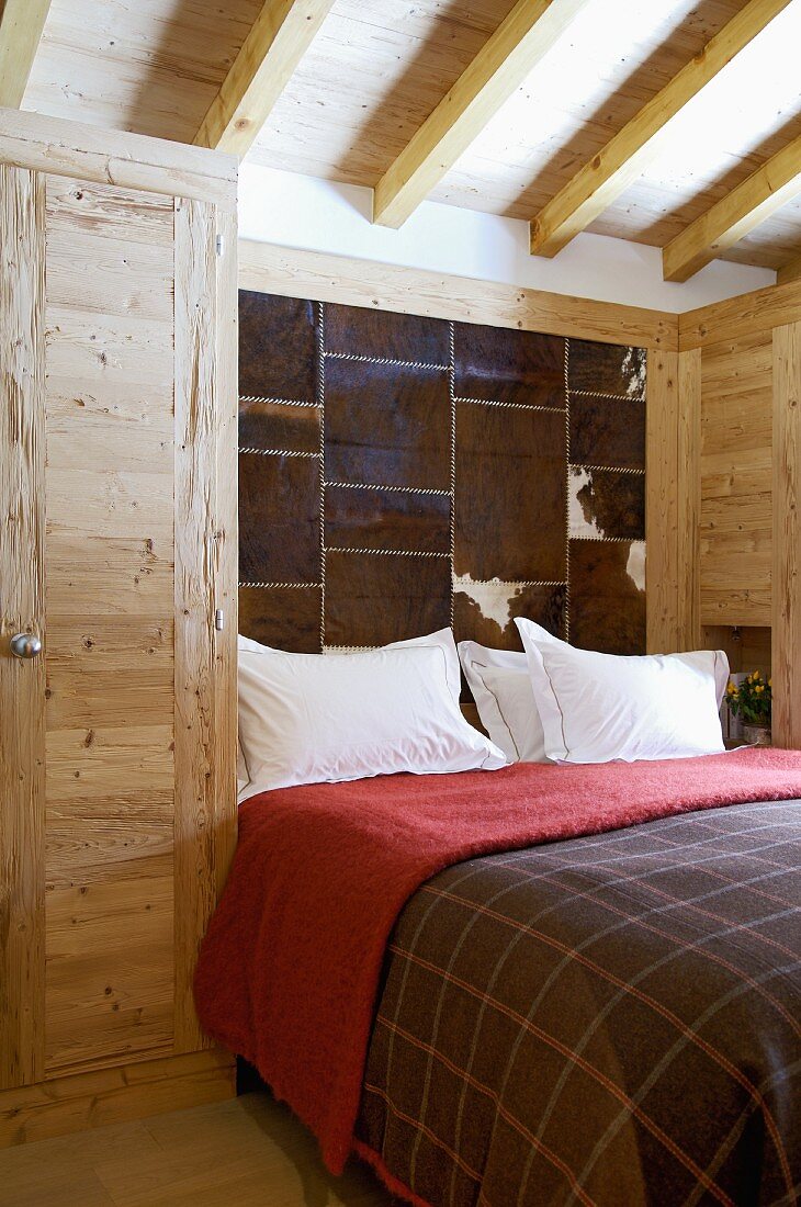 Modernes Schlafzimmer mit rustikalem Holzschrank und fellbezogenes Panel an Wand