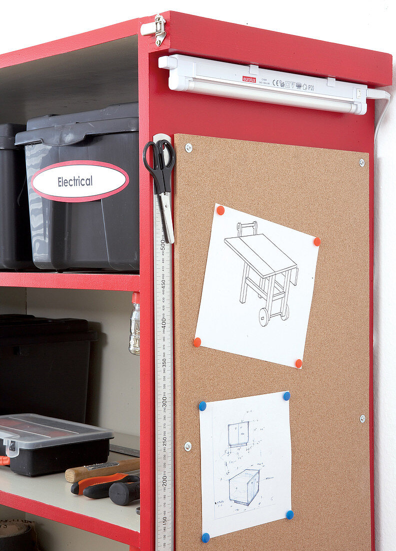 Pinboard and fluorescent tube on side of red tool cabinet