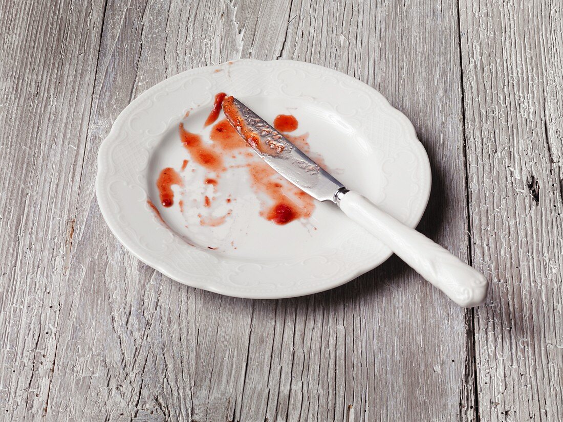 Reste von Erdbeerkompott auf Teller mit Messer