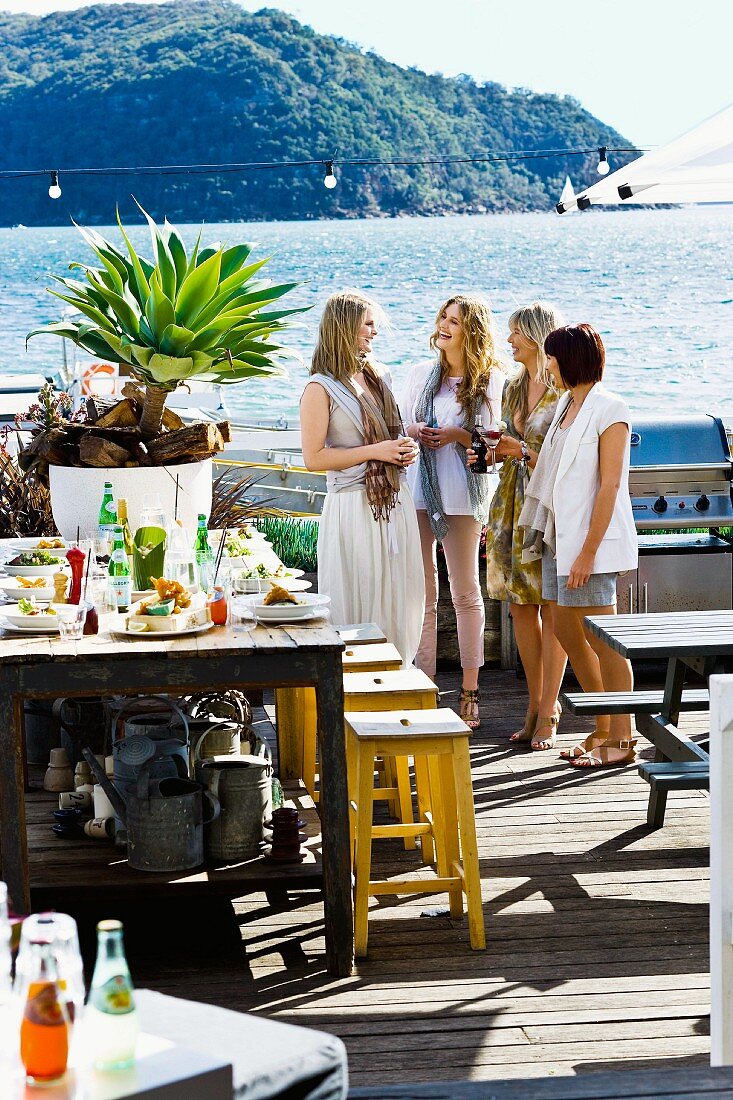 Frauen unterhalten sich beim gedeckten Tisch am Hafen