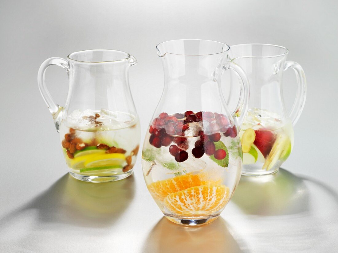 Three pitcher of ice water with fresh fruit